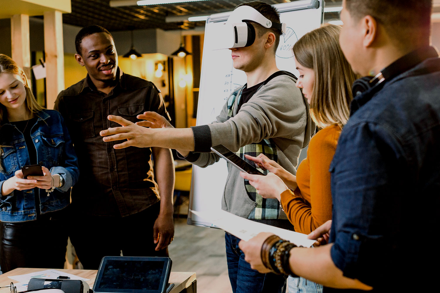 Diverse group of students using a VR headset in a meeting.