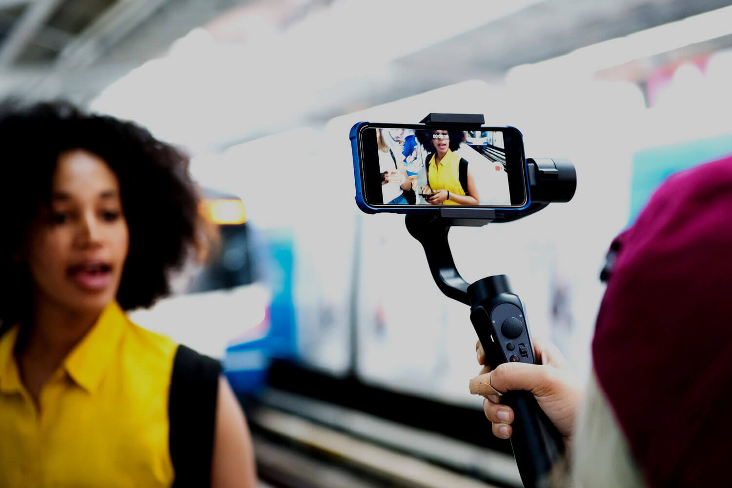 Young woman being filmed by a smartphone on a selfie stick