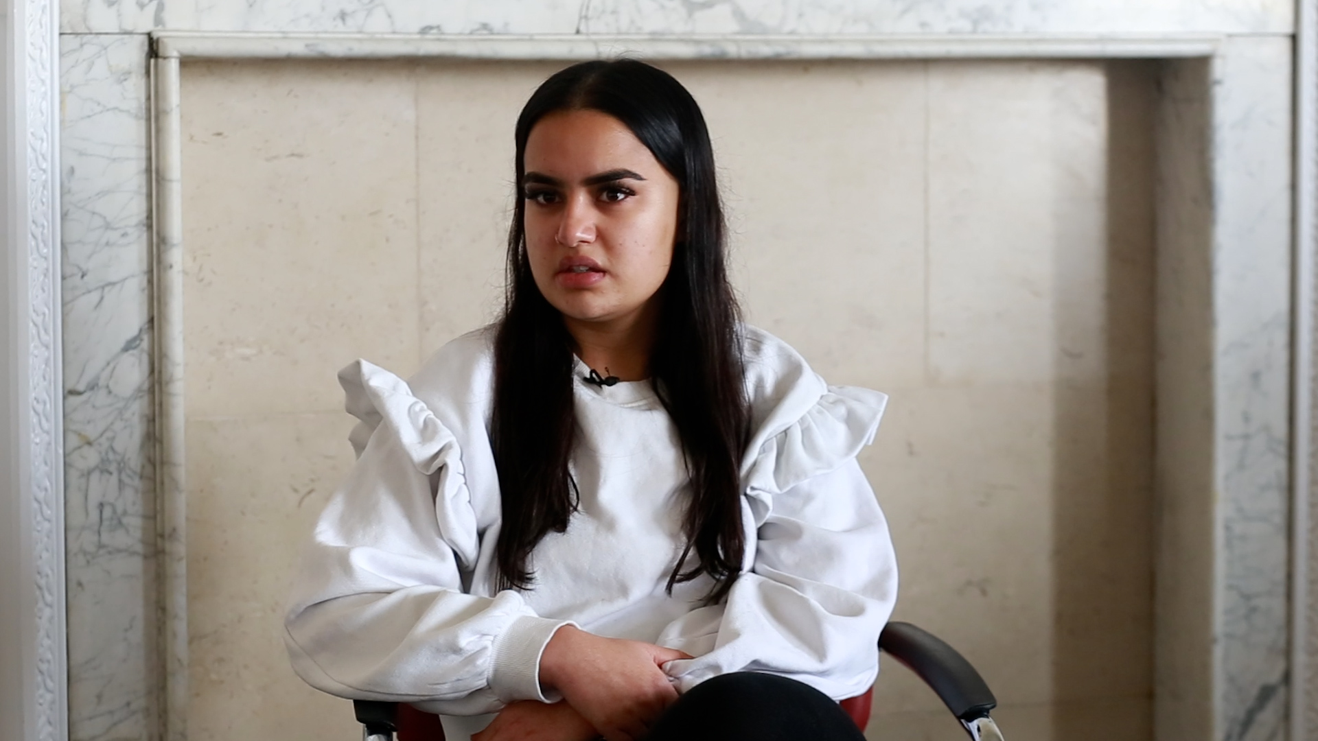 A woman student sitting down and talking to the camera