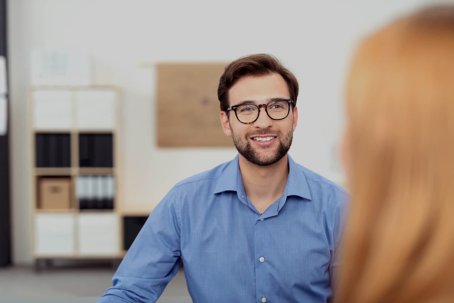 Man chatting to a female, view of his face past her hair.