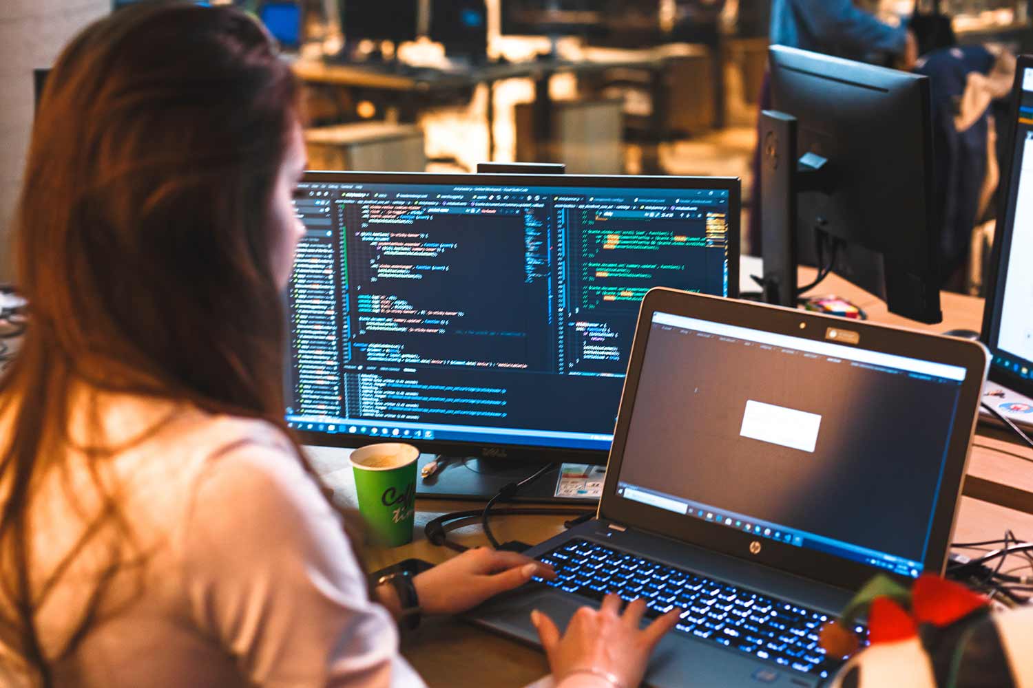 SOMEONE SITTING IN FRONT OF TWO MONITORS