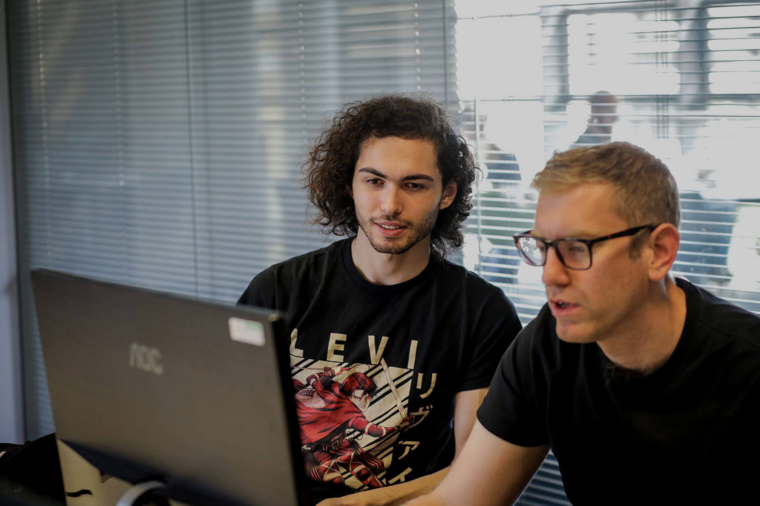 Tutor and student discussing what they're looking at on a laptop screen