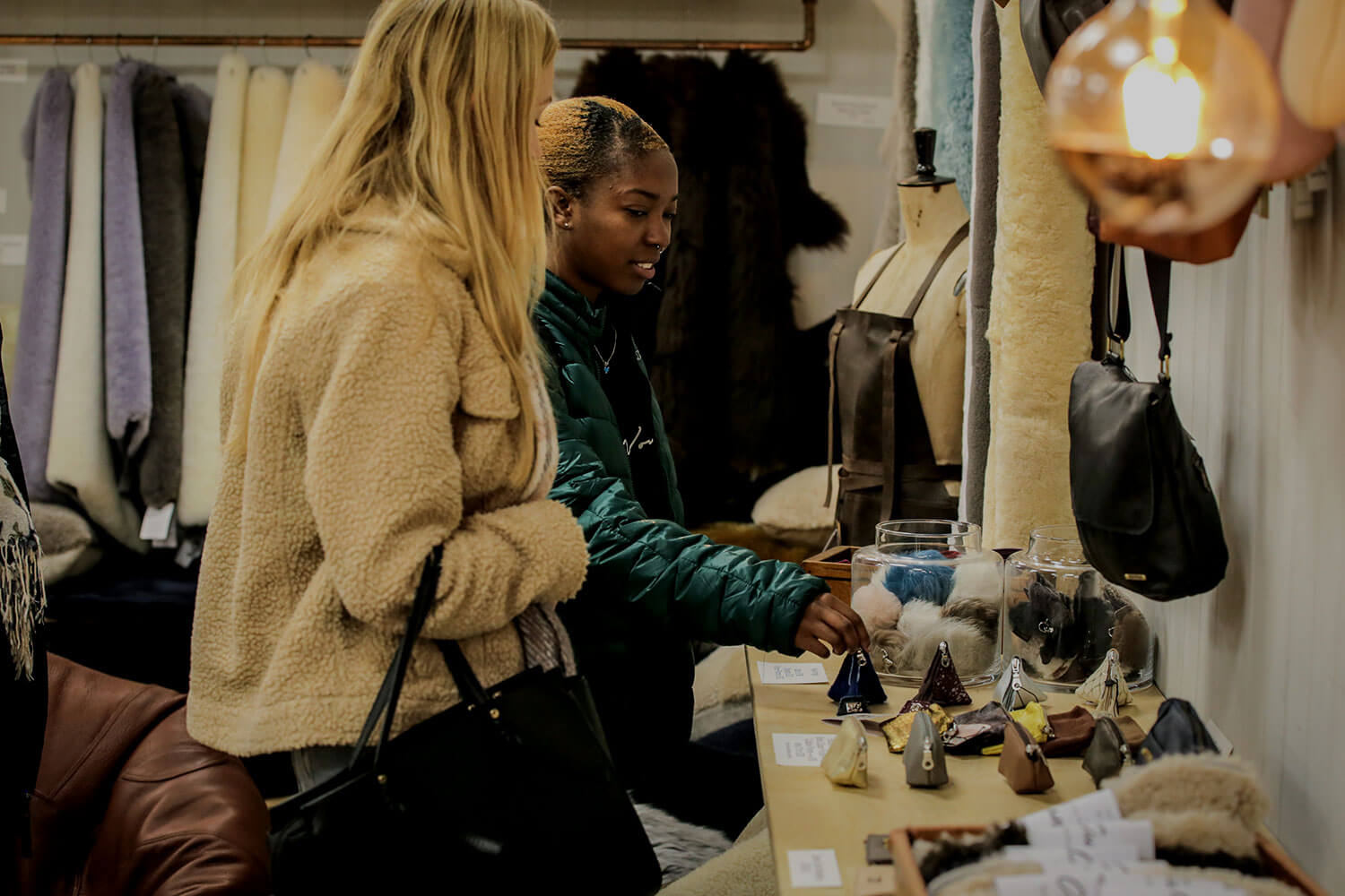 Two students examining purses in a leathercraft studio