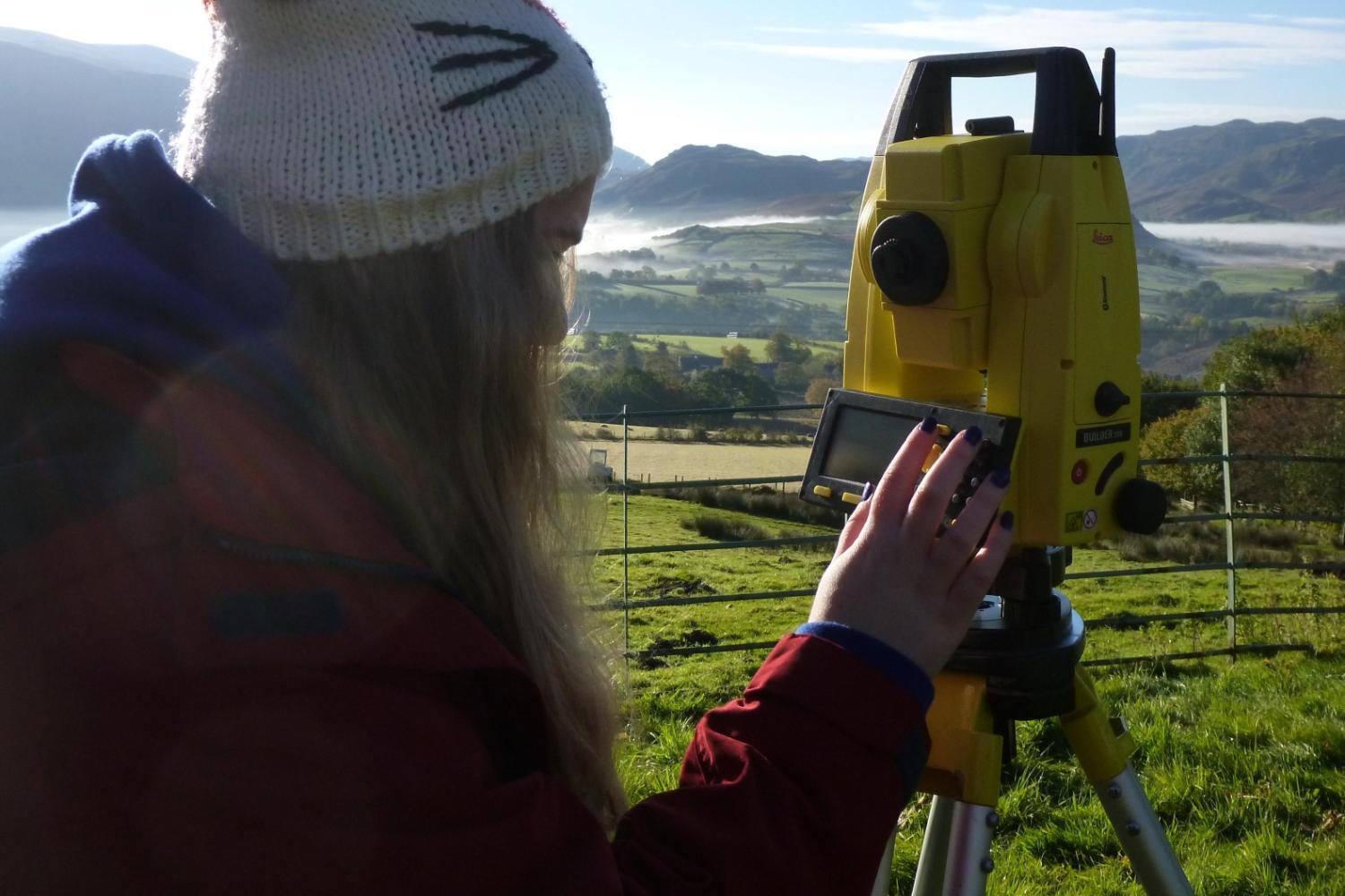 A student operates a piece of equipment on a field trip