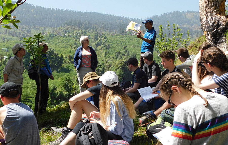 A group of students sitting on the side of a mountain