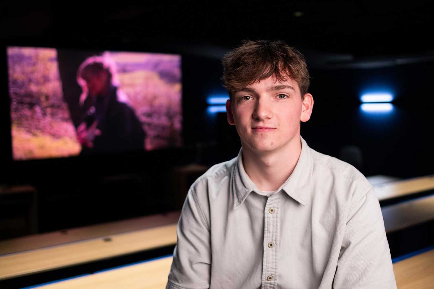 A person sits in front of a large cinema screen
