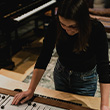 Photo of a young woman standing at a mixing desk