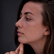 A profile photo of a young woman thinking