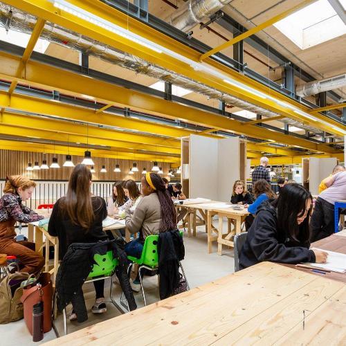 Students studying at Locksbrook campus with yellow piping along the ceiling