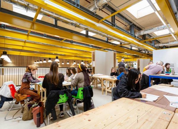 Students studying at Locksbrook campus with yellow piping along the ceiling