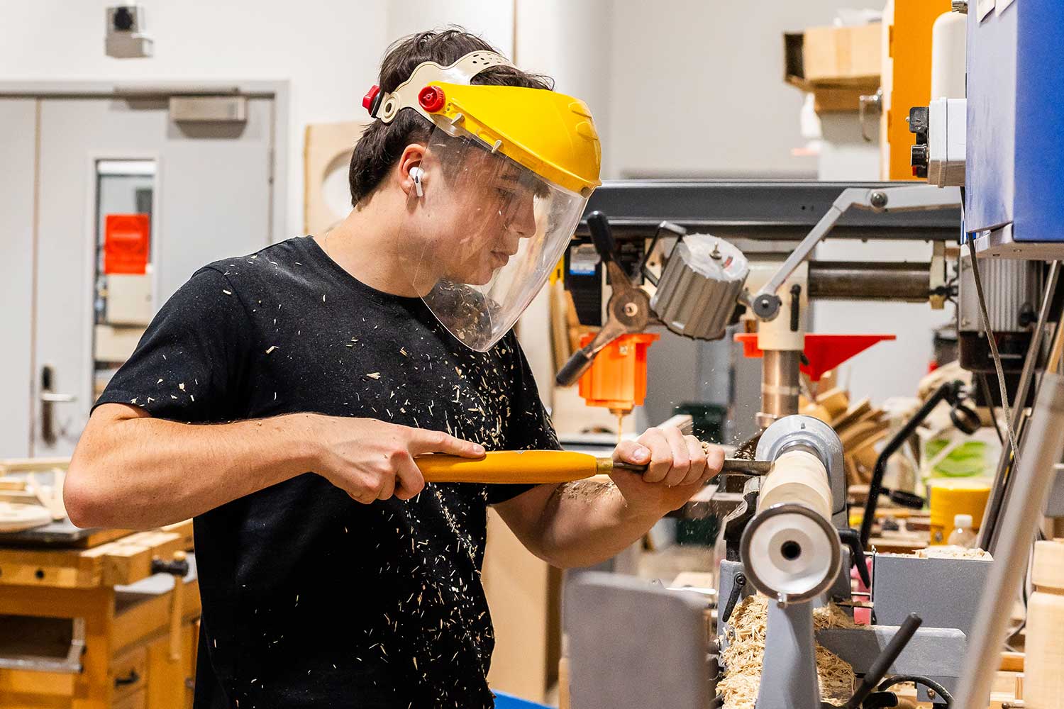 A student uses equipment in the woodwork workshop