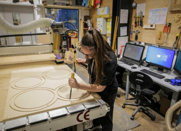 A student works on their design project in the woodwork workshop