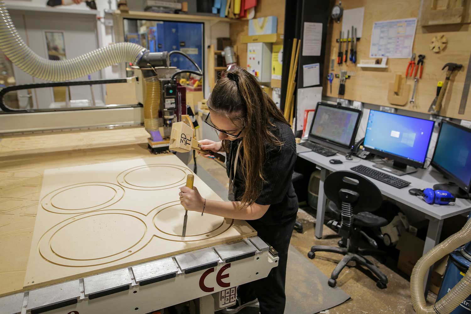 A student works on their design project in the woodwork workshop