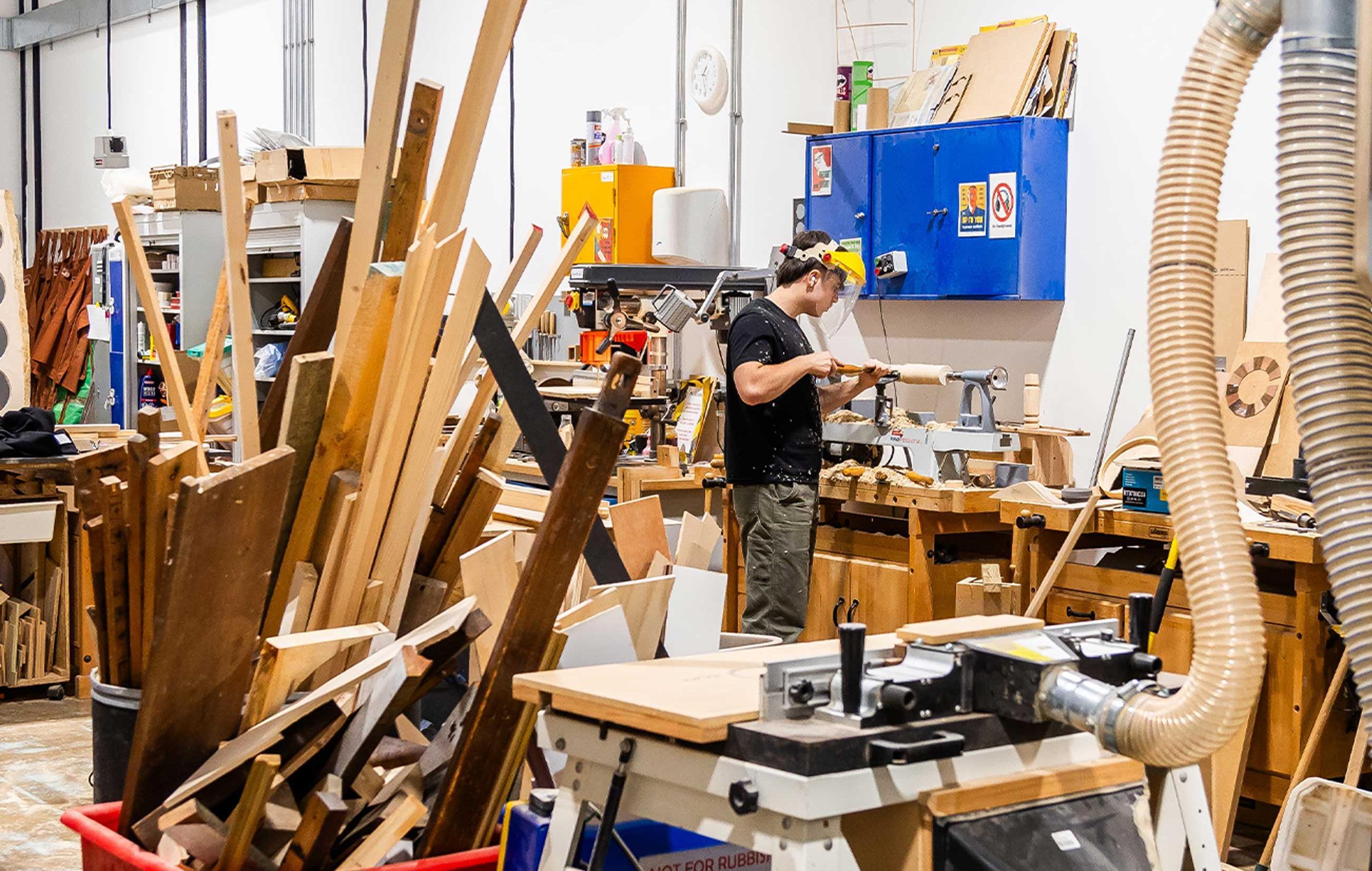 A woodwork workshop with lots of machinery and materials ladden around
