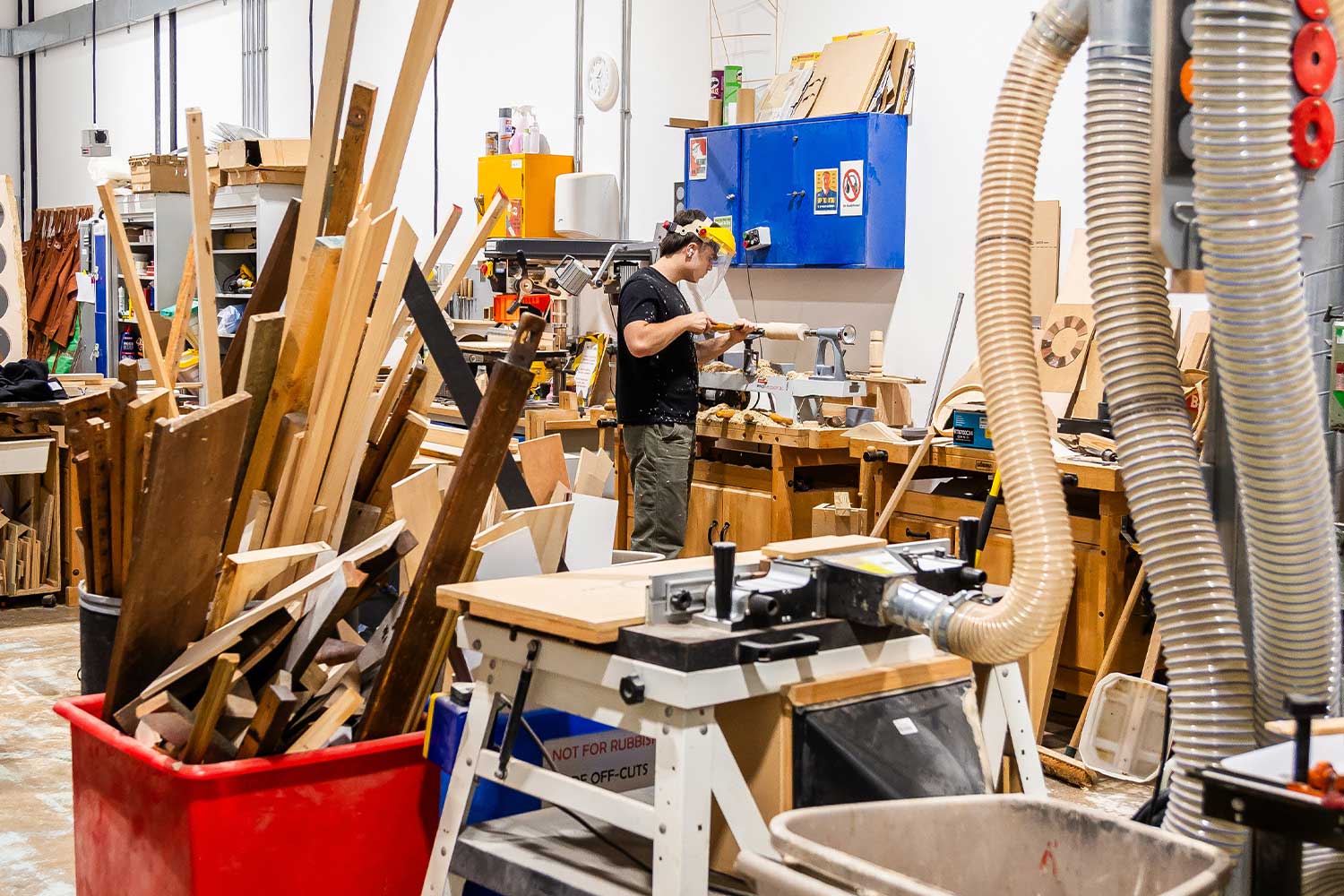 A woodwork workshop with lots of machinery and materials ladden around