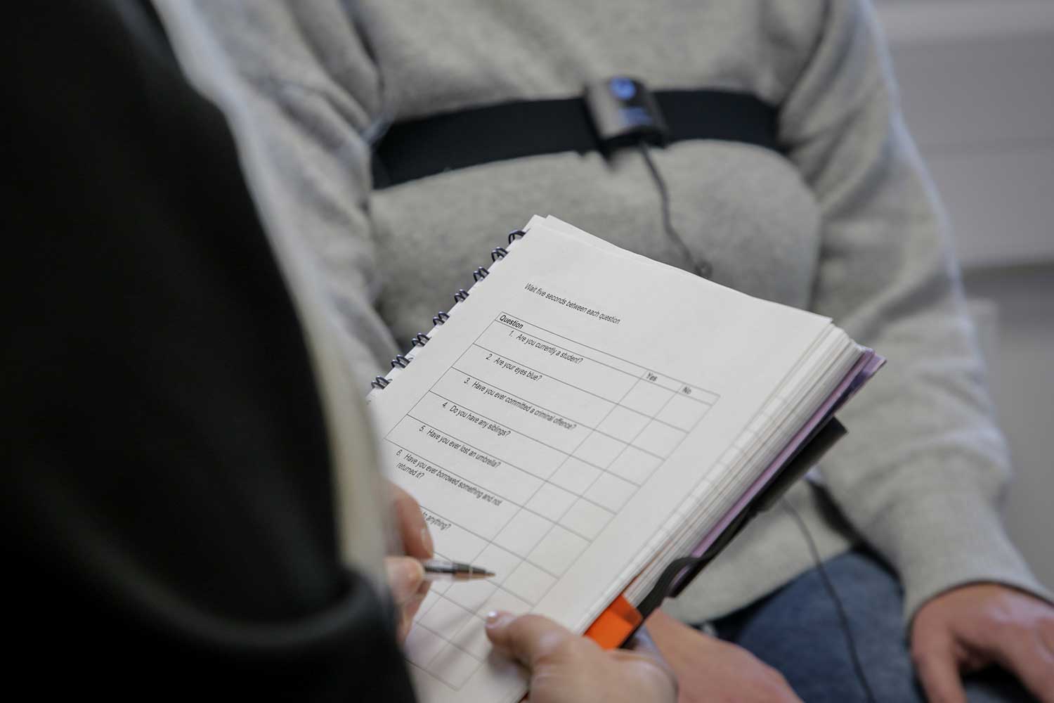 A close up shot of a student taking notes in a notepad