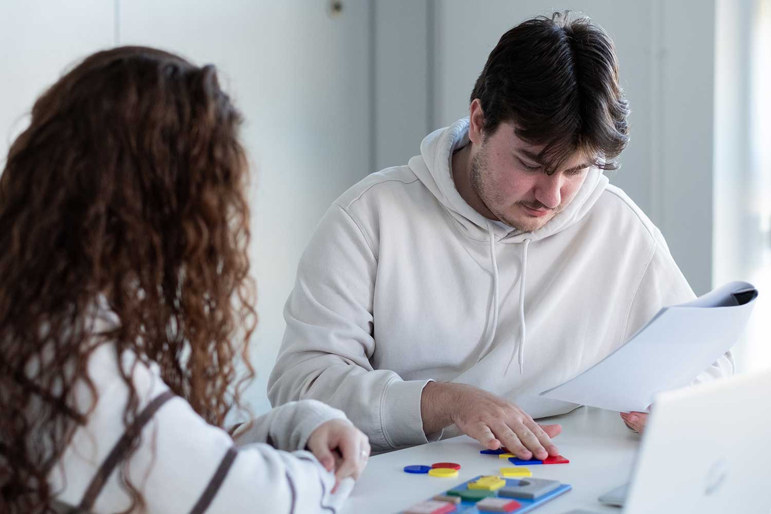 Two students work on a practical task with wooden pieces