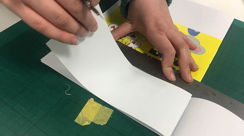 Close up of a person's hands as they bind a book