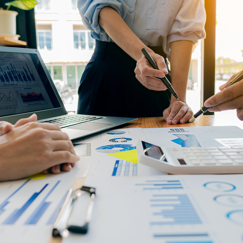 People standing over flowcharts on a desk in an office environment