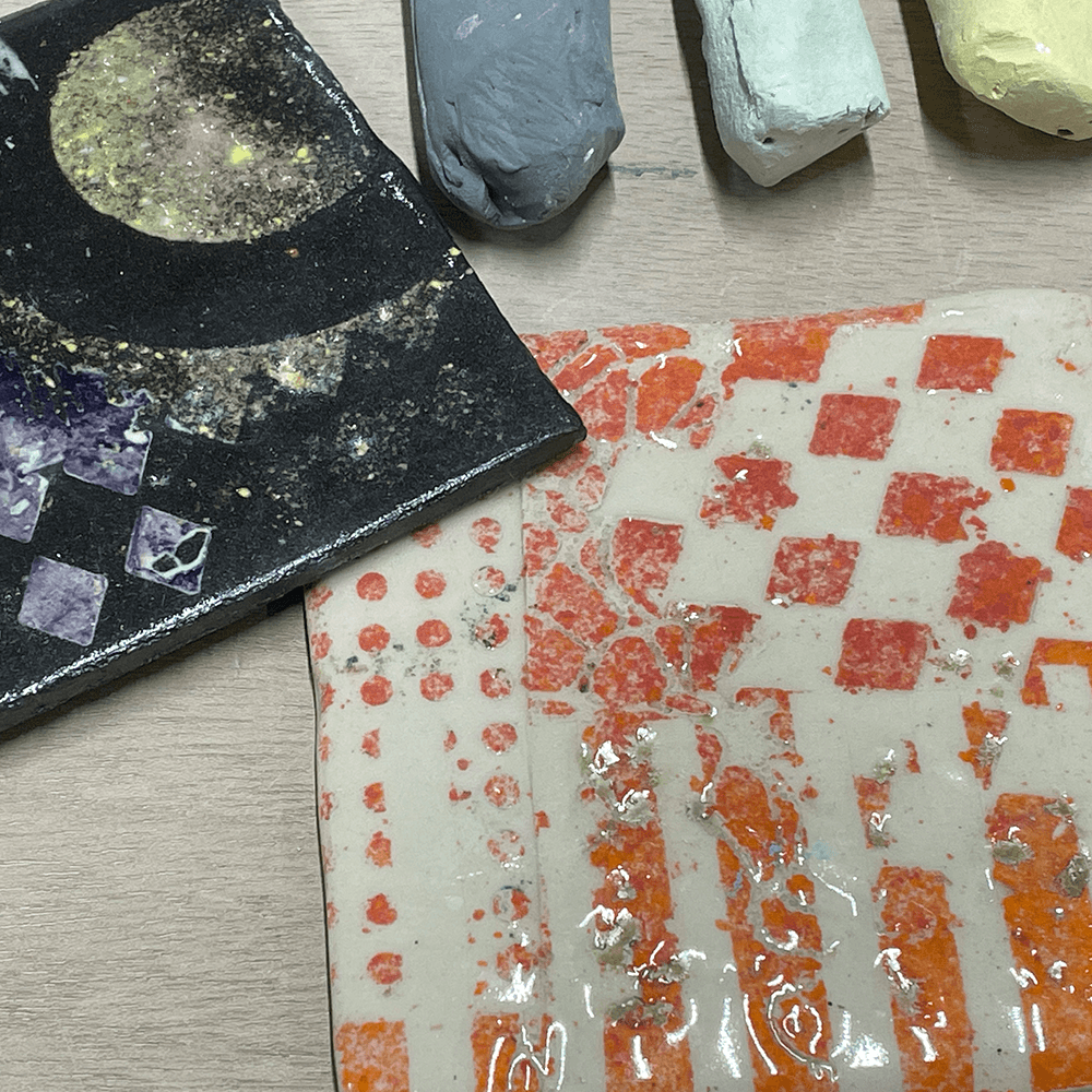 Two ceramic tiles with three sticks of chalk above