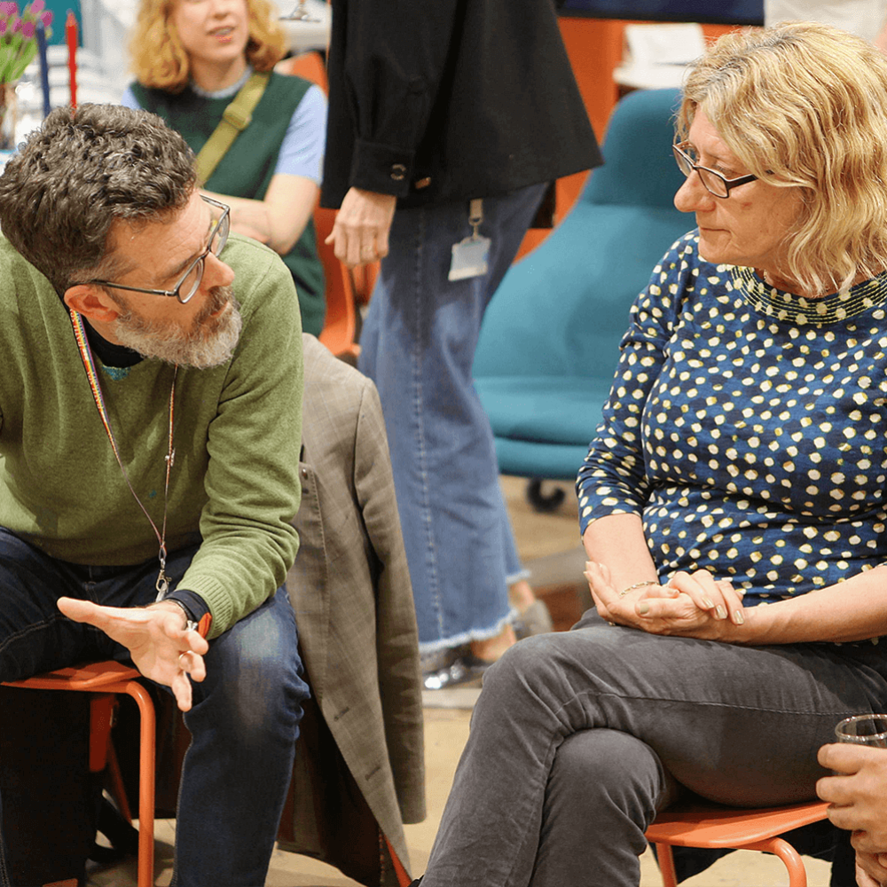 Three people sat on chairs talking to each other