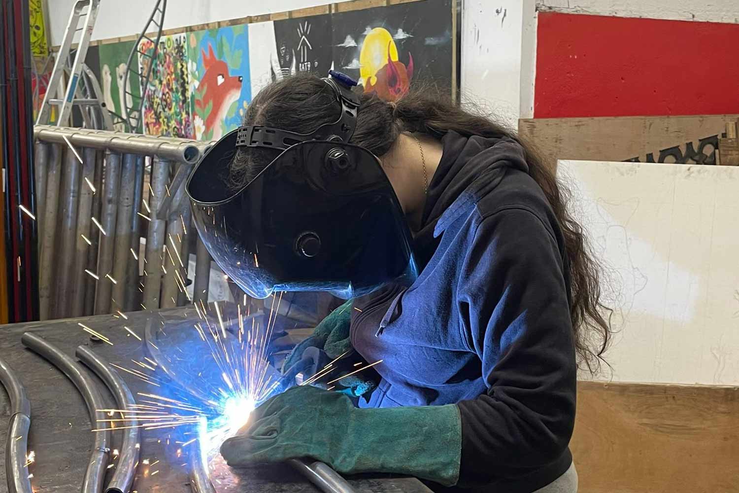 Someone with mask on welding in a workshop
