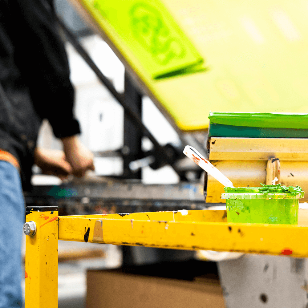 A photo of a technician preparing a yellow silk screen for printing