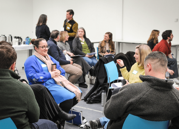 A group of people sat on chairs talking to one another