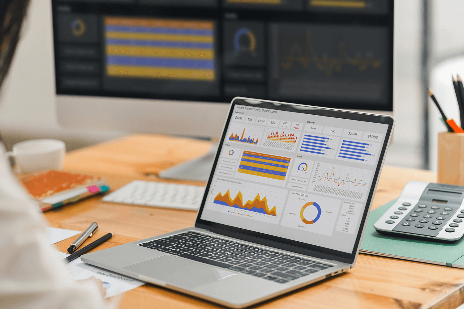 A laptop sits on the desk showing a data dashboard