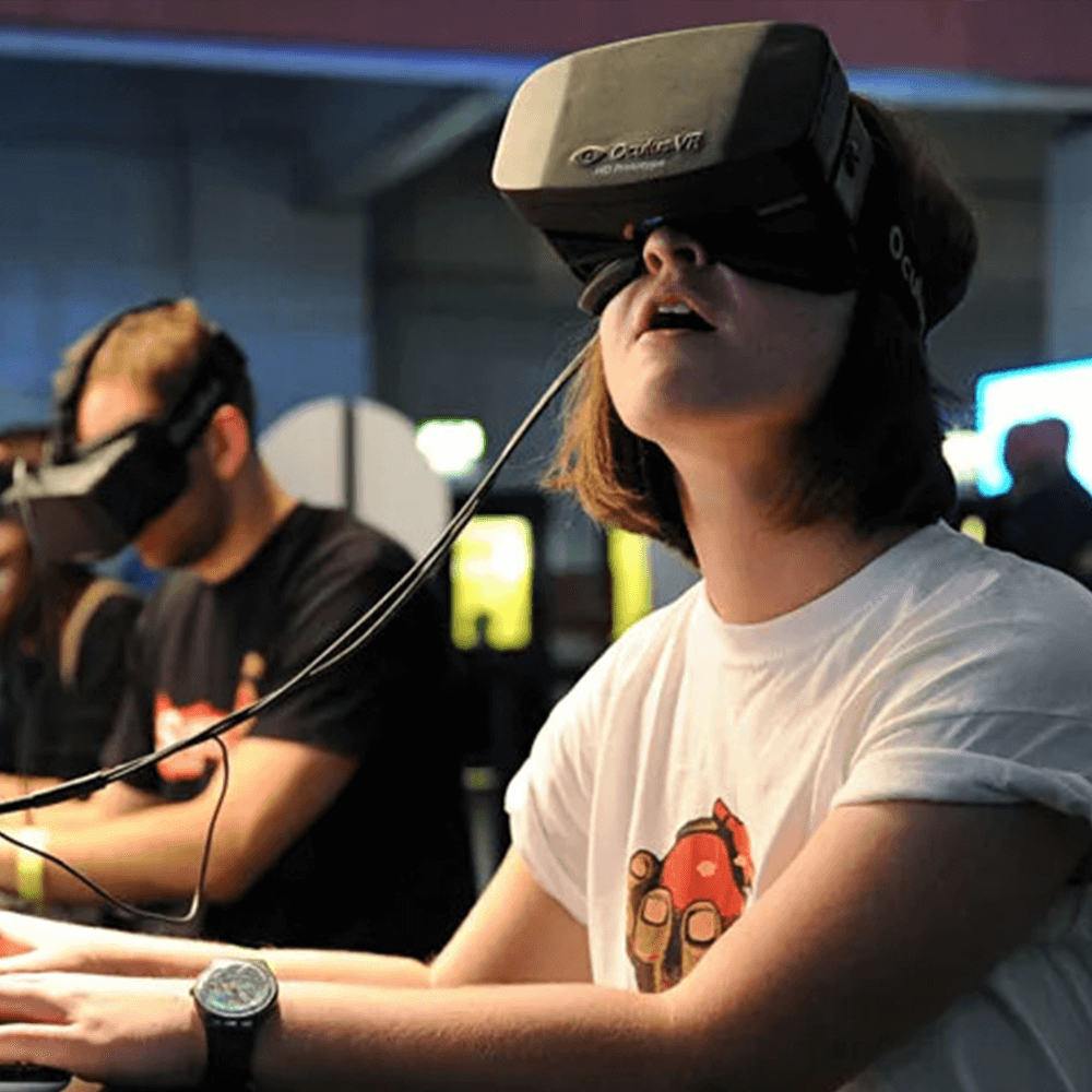 A person sits at a desk with a VR headset on