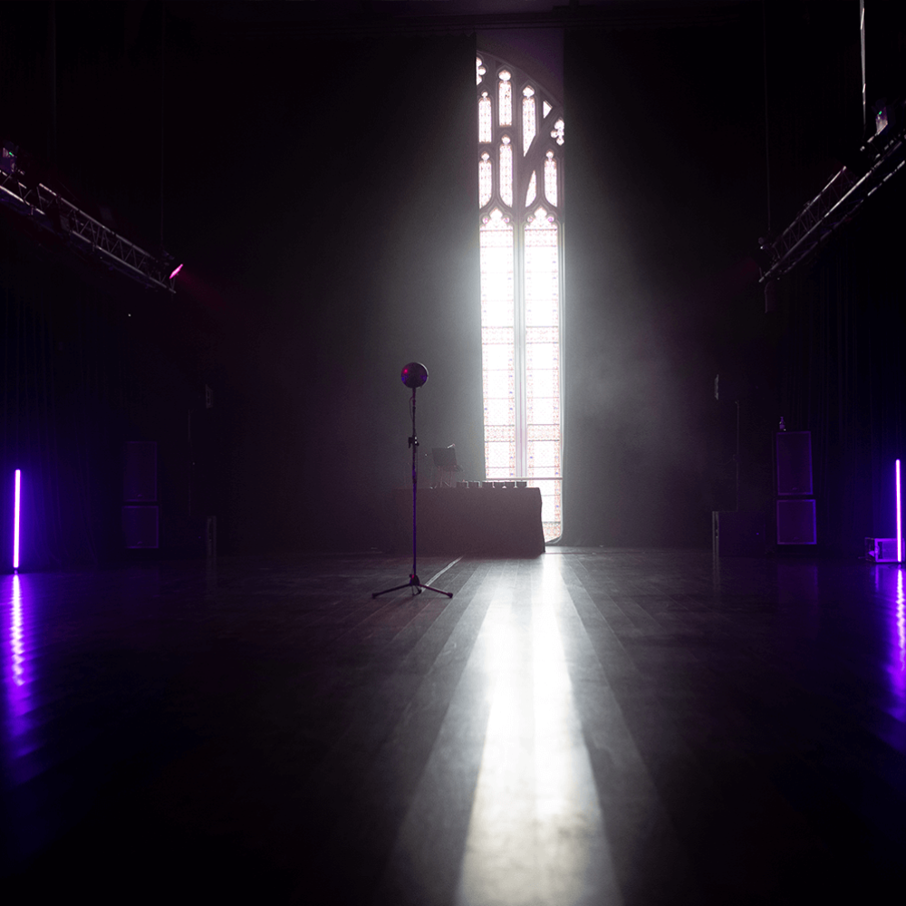 An empty church hall with a microphone on a stand in the centre of the room