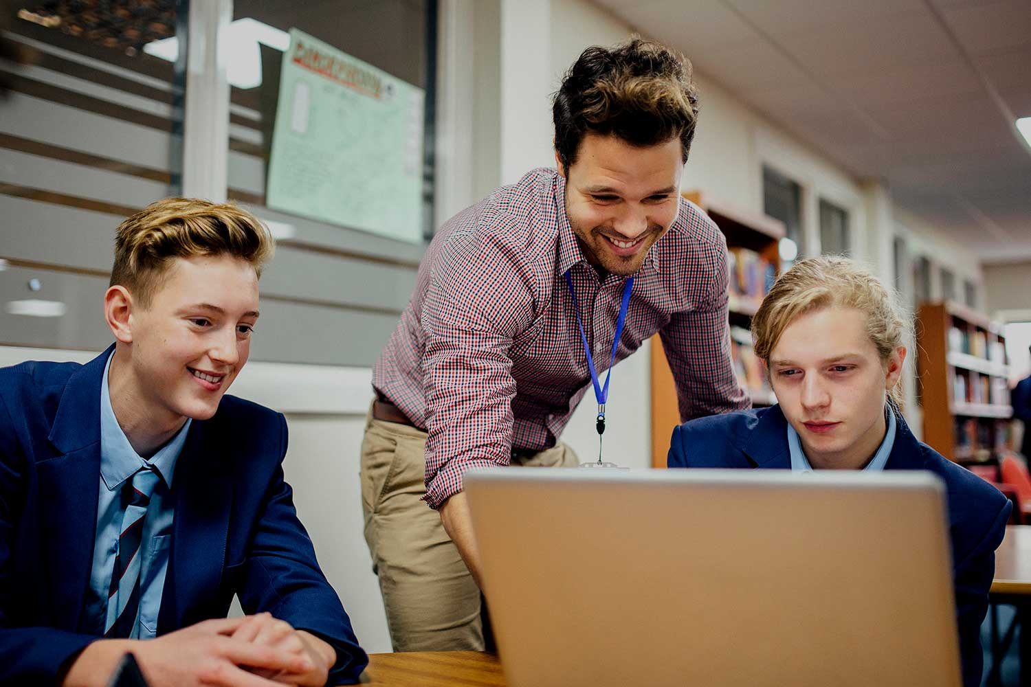 A teacher helps two secondary school pupils