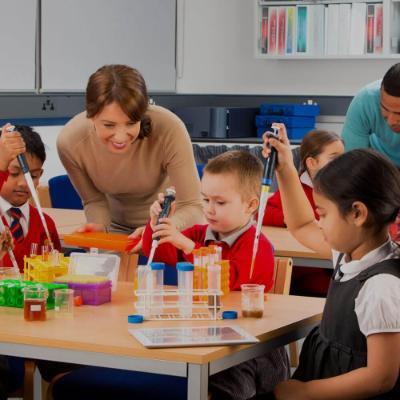 Primary school children using pipettes and beakers during a science lesson