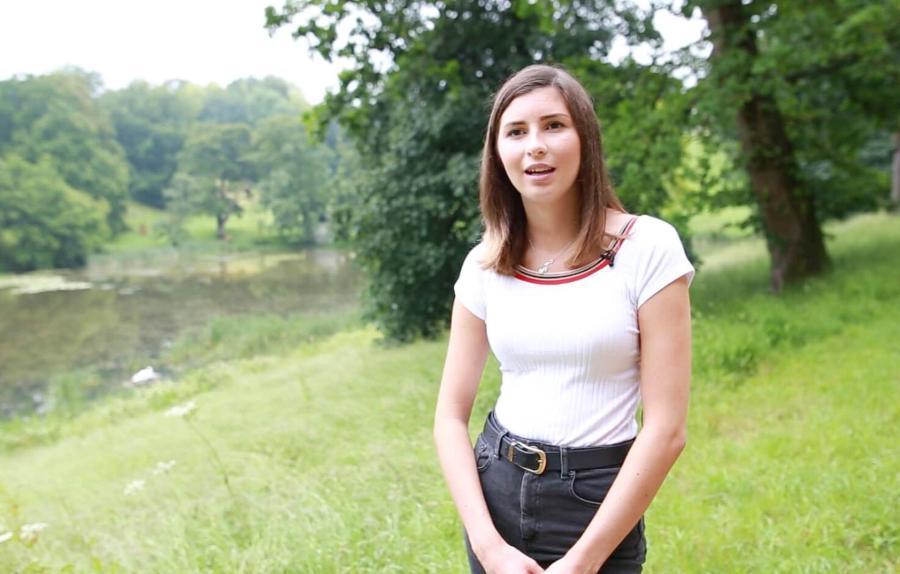 student stood lakeside