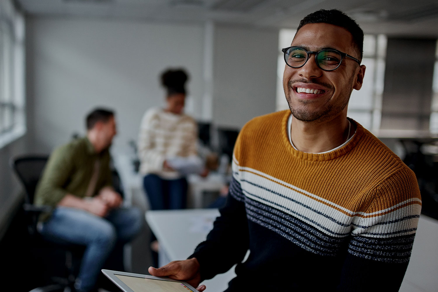 Man with digital tablet smiling to camera in a working environment