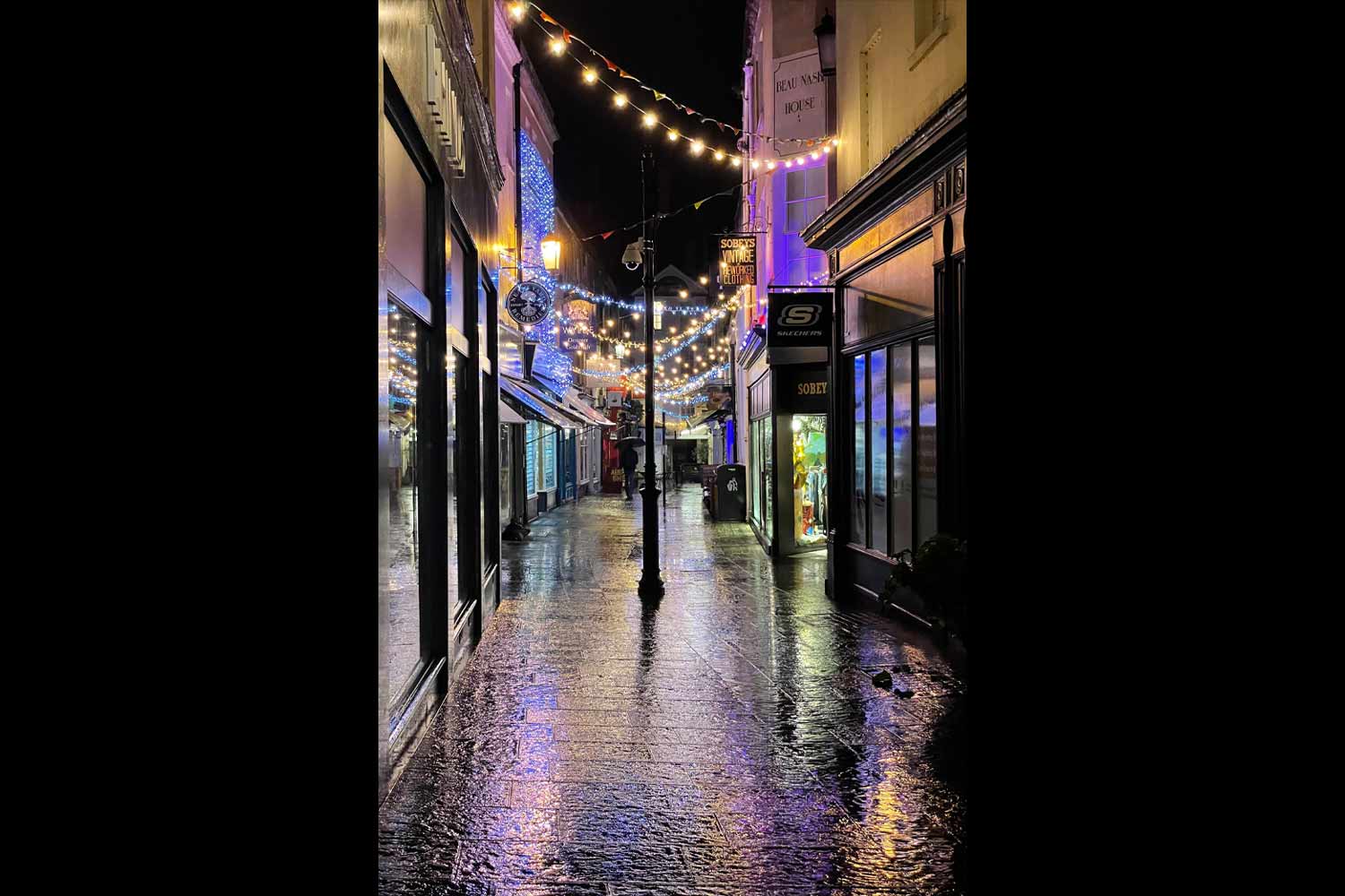 image placed in 2025 international photo comp showing wet stoned lane in bath with streets festooned by lighting