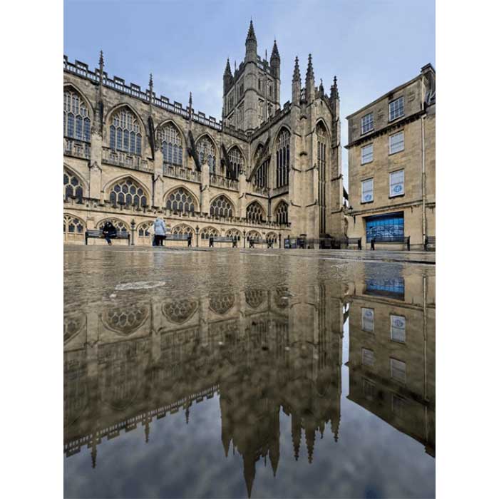 A reflection of Bath Abbey in a puddle