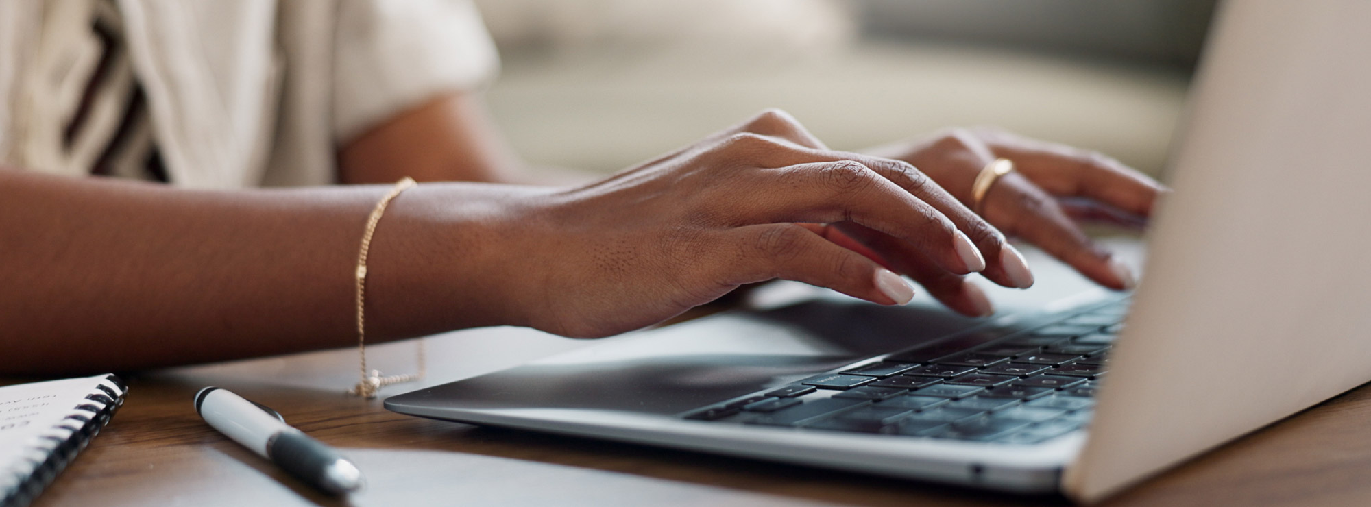 A closeup view of a person typing on the keyboard of a laptop