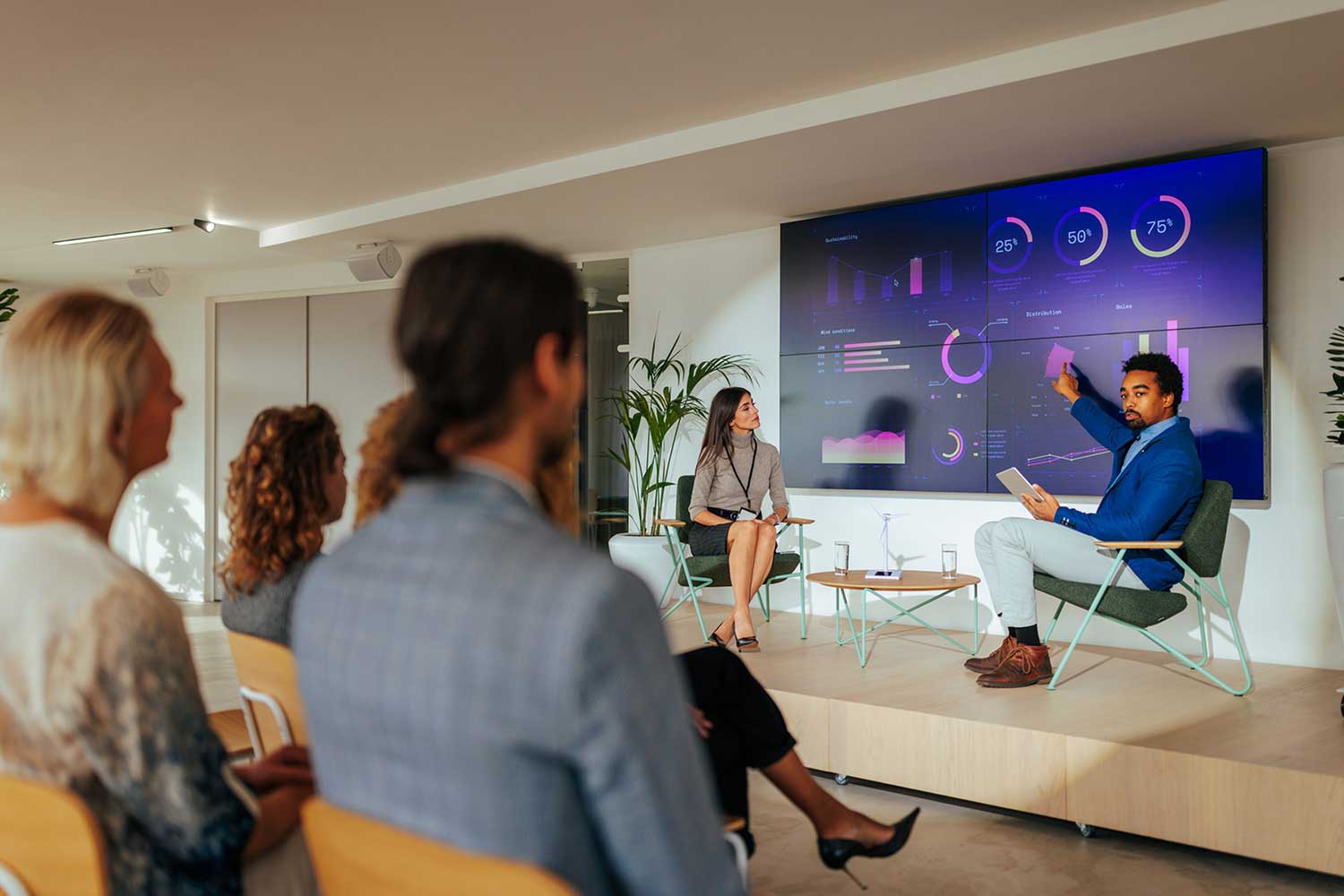 A diverse group of colleagues watch a presentation being given