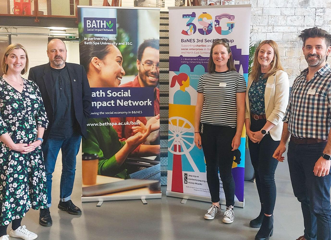 A group of people stood in front of two pull-up banners