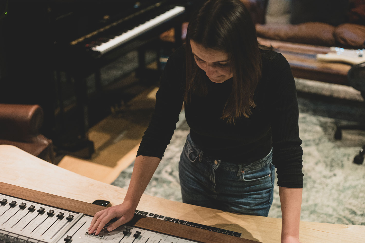 A student stood over a music mixing board