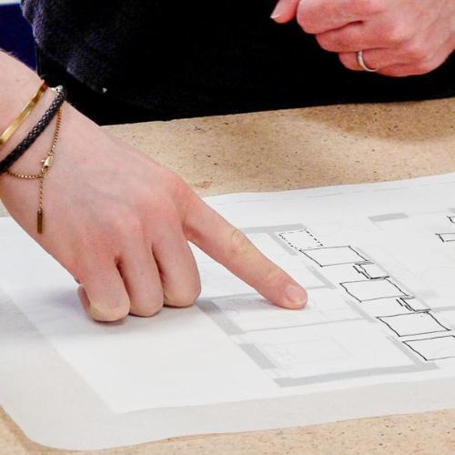 People pointing at some architecture design drawings