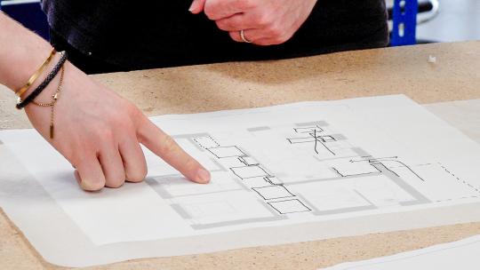 People pointing at some architecture design drawings