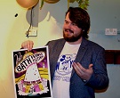 A student holding up his winning poster