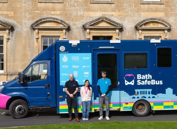 Two students and a Bath Safe Bus employee stand in front of the Bath Safe Bus