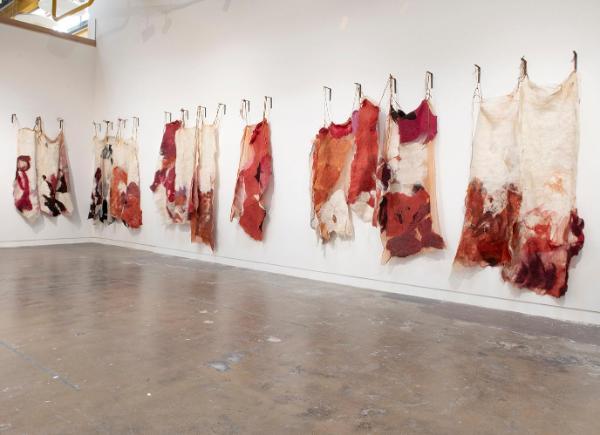 Art pieces made of wool hanging in a gallery