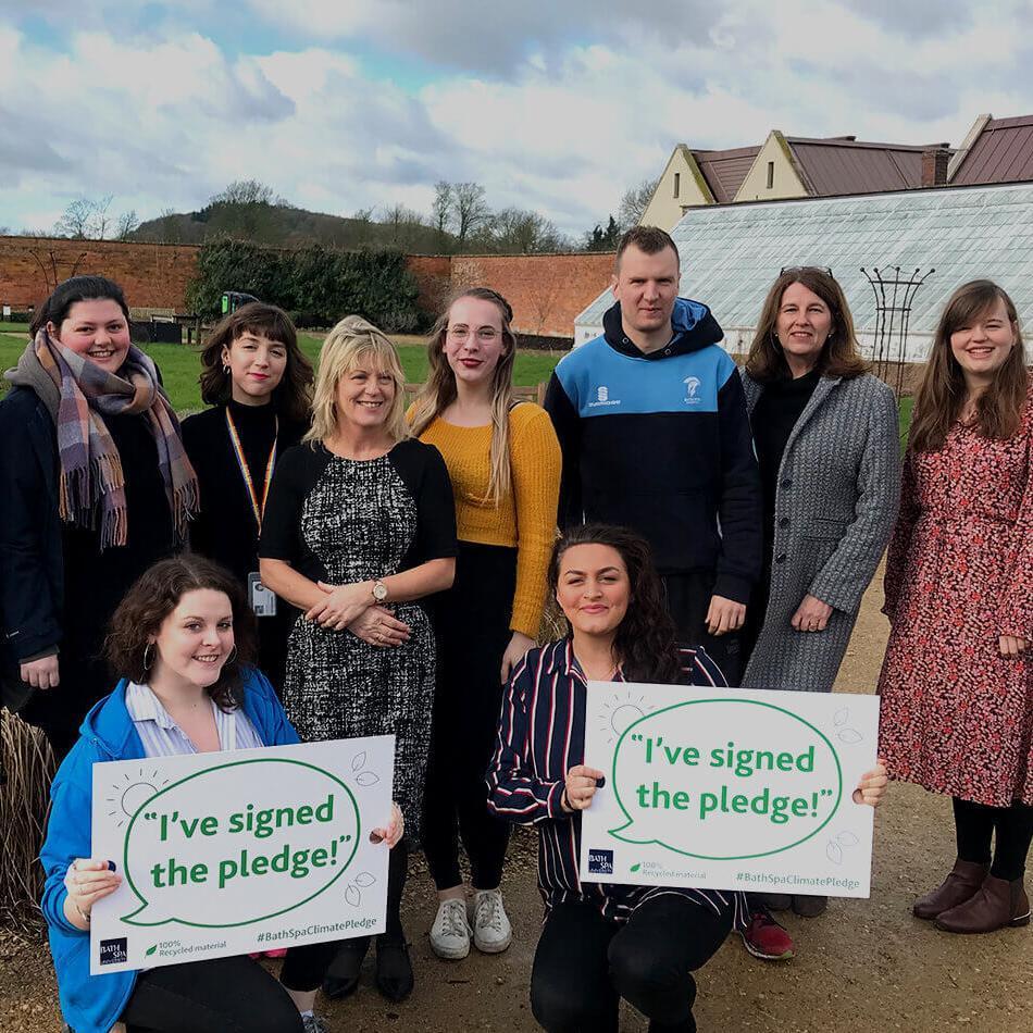 A group of people posing with signs that say 'I signed the pledge'
