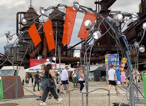 A display made of metal with flashing spotlights and bright red flags hanging from it