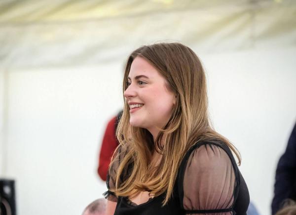 person standing up in an audience smiling