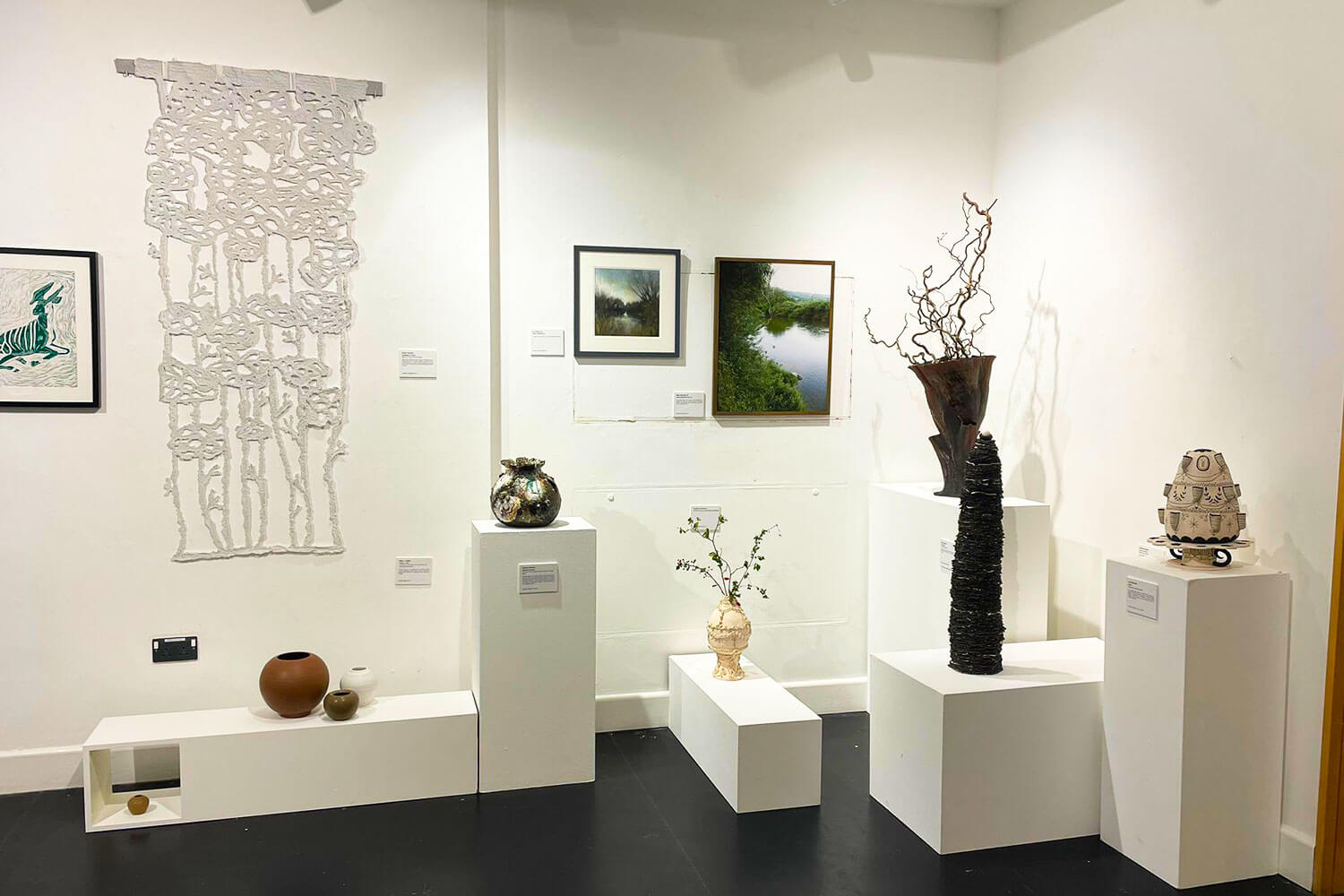 art work of various mediums on display in a gallery